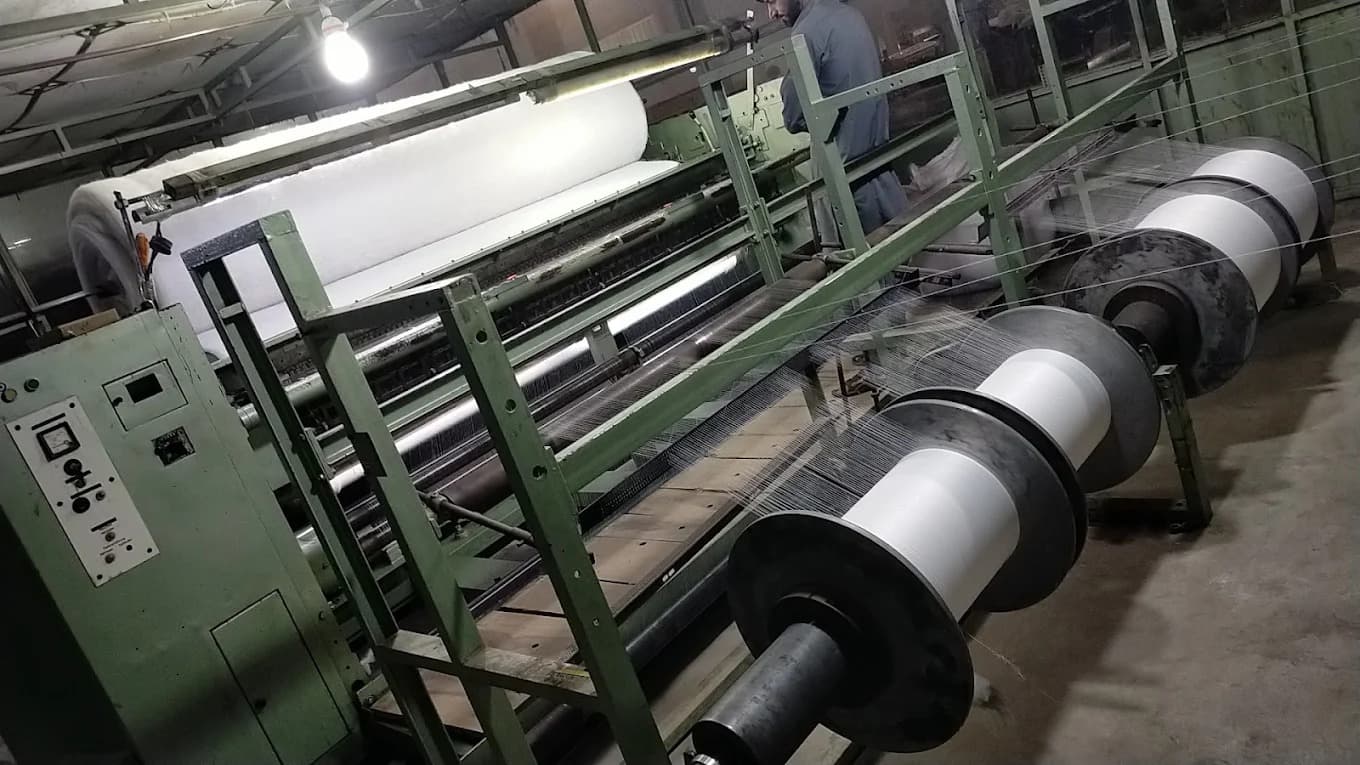 Stitch-bonding warp machine inserting yarn into fibrous batt