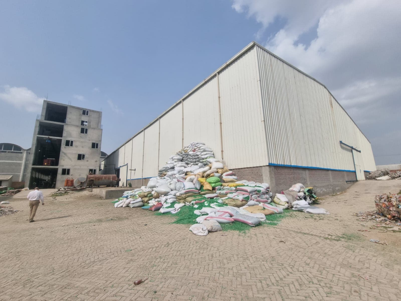 Wide plant campus grounds, material staging yard, and primary production warehouse